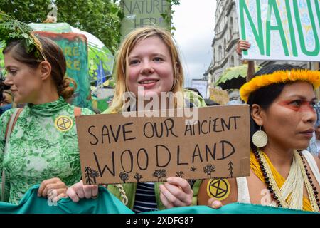 Londra, Regno Unito. 22 giugno 2024. Un manifestante tiene un cartello "Save Our Ancient Woodland" durante la marcia Restore Nature Now. Decine di migliaia di persone e numerosi gruppi di natura e fauna selvatica hanno marciato nel centro di Londra, chiedendo al governo di fare di più per ripristinare e proteggere la natura. Crediti: Vuk Valcic/Alamy Live News Foto Stock