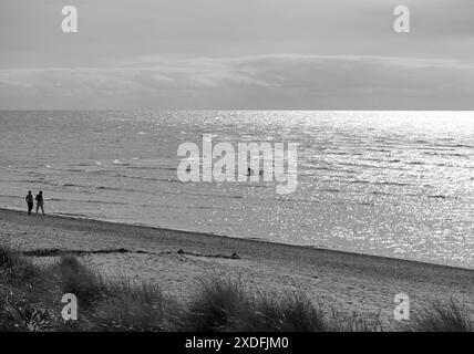 Una coppia distante che cammina su una spiaggia Foto Stock