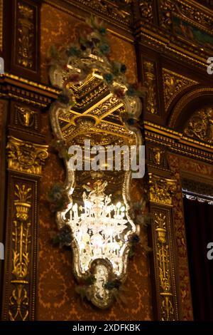 Sinaia, Romania - 26 agosto 2022: Lampadari in vetro colorato o lampada riflessa nello specchio all'interno del castello di Peles. L'interno ricco di T Foto Stock