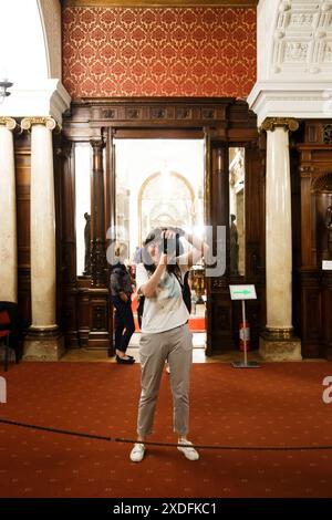 Sinaia, Romania - 26 agosto 2022: La ragazza turistica fa selfie fotografici il suo riflesso nello specchio all'interno del castello di Peles. L'interno ricco del PE Foto Stock