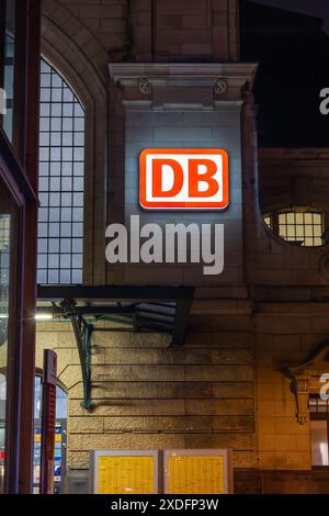 Coblenza, Germania - 19 febbraio 2024: Il cartello DB illuminato (Deutsche Bahn, ferrovia tedesca) è montato sull'edificio in mattoni della stazione ferroviaria di Coblenza Foto Stock