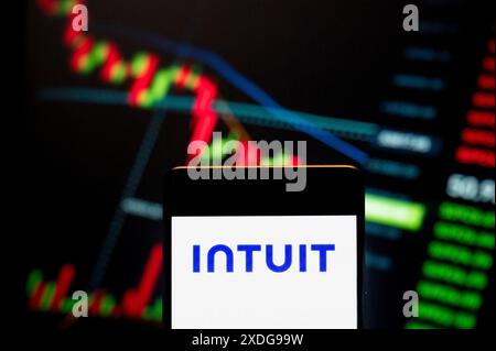 Cina. 21 giugno 2024. In questa immagine, il logo della società americana di software aziendale Intuit (NASDAQ: INTU) visualizzato su uno smartphone con un grafico dell'indice di borsa sullo sfondo. Credito: SOPA Images Limited/Alamy Live News Foto Stock