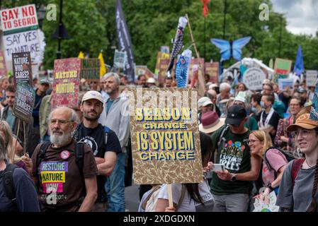 Londra, Regno Unito. 22 giugno 2024. I manifestanti tengono cartelli e bandiere d'onda durante la marcia a Londra. Restore Nature è stato il più grande raduno del Regno Unito per la natura e il clima. Oltre 300 organizzazioni hanno preso il controllo delle strade di Londra. I dimostranti hanno chiesto azioni urgenti per ripristinare la natura e affrontare il cambiamento climatico. Credito: SOPA Images Limited/Alamy Live News Foto Stock