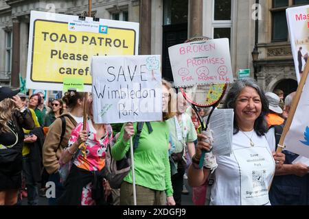 Londra, Regno Unito, 22 giugno 2024. I manifestanti portano cartelli contro lo sviluppo proposto dall'espansione All England Lawn Tennis Club. Migliaia di persone partecipano alla marcia di Restore Nature Now con rappresentanti di oltre 300 enti di beneficenza e gruppi di azione diretta a Westminster che sollecitano un'azione su urgenti problemi climatici come l'inquinamento idrico e le specie in via di estinzione. Credito: Fotografia dell'undicesima ora/Alamy Live News Foto Stock