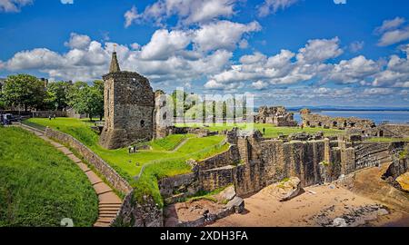 St Andrews Castle Fife, Scozia, il sole e il cielo blu sopra le rovine e una piccola spiaggia di sabbia Foto Stock