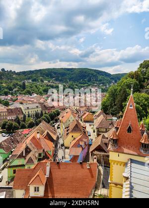 Tetti piastrellati dell'antica greentown europea sullo sfondo del cielo blu con nuvole. Patrimonio medievale. Vista pittoresca. Immerso nel verde ondulato della hil Foto Stock