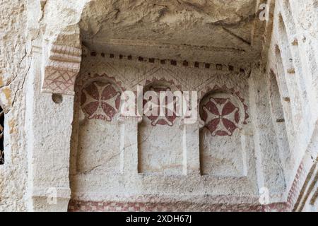 GOREME, TURCHIA - 4 OTTOBRE 2020: Questo è un frammento delle rovine di una delle chiese rupestri con disegni cristiani conservati e una croce nell'ope Foto Stock