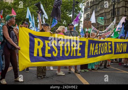 Londra / Regno Unito - 22 giugno 2024: Attivisti per il clima protestano al Restore Nature Now march per la protezione ambientale. 350 gruppi tra cui RSPB, WWF, National Trust, Extinction Rebellion e altri si unirono per la marcia. Foto Stock