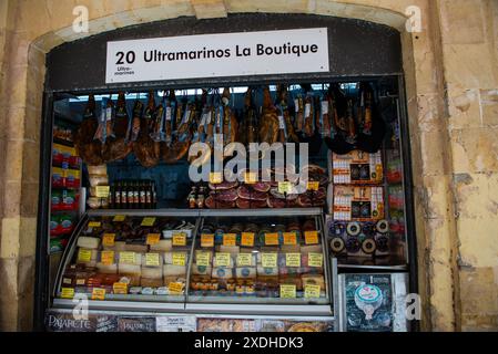 Un chiosco di prosciutto e formaggio espone i suoi prodotti in un mercato a Cadice, in Spagna. Foto Stock
