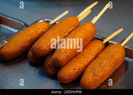 I Corndog sono hot dog fatti con pastella di farina di mais fritta in olio caldo da cucina Foto Stock
