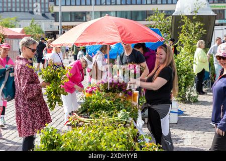 Fiorista che vende fiori e betulla nella piazza del mercato di Hakaniemi, Helsinki, Finlandia, la vigilia di mezza estate, 21 giugno 2024. Foto Stock