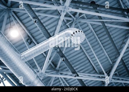 Tubi di ventilazione in color argento per il materiale di isolamento che pendevano dal soffitto all'interno di edificio di nuova costruzione. Foto Stock