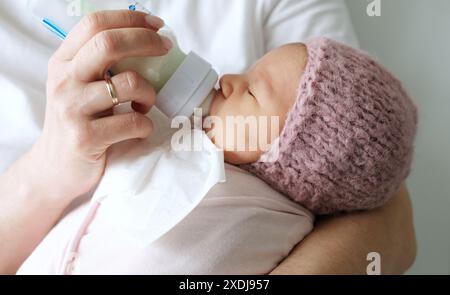 Mamma che le regala la formula per il latte neonato da Una bottiglia Foto Stock