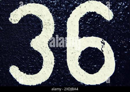 Numero 36, numero bianco su sfondo scuro. Foto Stock