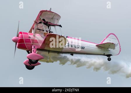 Sywell Aerodrome, Northamptonshire, Regno Unito. 23 giugno 2024. Il Sywell Airshow è un nuovo evento nel calendario dello show aereo. Una rivisitazione della consueta esposizione di "girl-on-the-Wing" ha visto Danielle del buono muoversi intorno alle ali del biplano d'epoca Boeing Stearman con il display 46 Aviation pilotato dal marito Emiliano Foto Stock