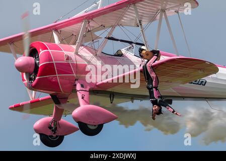 Sywell Aerodrome, Northamptonshire, Regno Unito. 23 giugno 2024. Il Sywell Airshow è un nuovo evento nel calendario dello show aereo. Una rivisitazione della consueta esposizione di "girl-on-the-Wing" ha visto Danielle del buono muoversi intorno alle ali del biplano d'epoca Boeing Stearman con il display 46 Aviation pilotato dal marito Emiliano Foto Stock