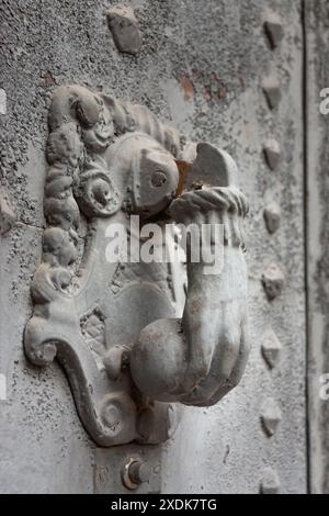 Battente di pietra trasparente a forma di mano che tiene una palla per poter bussare alla porta. Ha una base su cui si chiama. Foto Stock