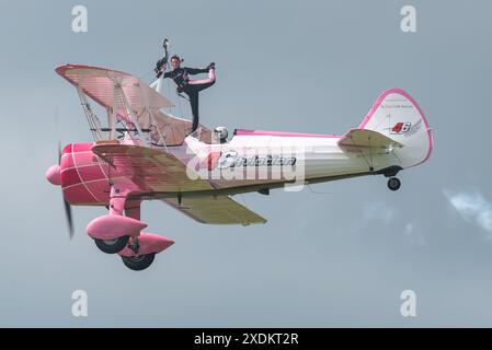 Sywell Aerodrome, Northamptonshire, Regno Unito. 23 giugno 2024. Il Sywell Airshow è un nuovo evento nel calendario dello show aereo. Una rivisitazione della consueta esposizione di "girl-on-the-Wing" ha visto Danielle del buono muoversi intorno alle ali del biplano d'epoca Boeing Stearman con il display 46 Aviation pilotato dal marito Emiliano Foto Stock