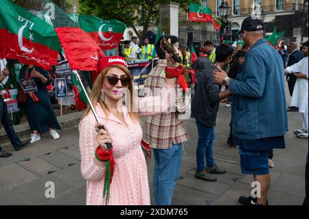 Londra, Regno Unito. 23 giugno 2024. Il dimostratore tiene una bandiera durante il rally. I sostenitori del partito Pakistan Tehrik-e-Insaf (PTI) dell'ex primo ministro imprigionato Imran Khan manifestano fuori 10 Downing Street chiedendo il rilascio di Imran Kahn e i lavoratori del PTI incarcerati. Credito: SOPA Images Limited/Alamy Live News Foto Stock