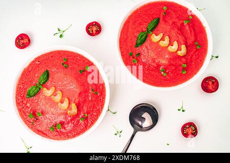 Zuppa di purè di pomodoro con basilico e sedano su sfondo chiaro. Cibo pulito, dieta, concetto di cibo vegano. Vista dall'alto. Foto di alta qualità Foto Stock