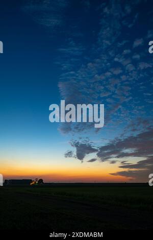 Le nuvole di pecore di Altcumulus sono splendidamente illuminate dal crepuscolo durante una notte di mezza estate a giugno Foto Stock