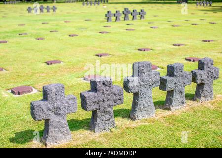 Le antiche croci del cimitero militare tedesco, situato in Normandia, Francia, evidenziano la sua storia cupa e i suoi dintorni sereni. Foto Stock