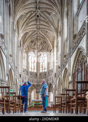 Fotografia del grandioso interno di Eglise Saint Pierre a Caen, Normandia, Francia, con una splendida architettura gotica e due persone che ammirano il Foto Stock