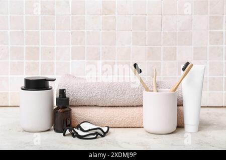 Set di articoli da bagno con spazzolini da denti sul tavolo contro le pareti di piastrelle leggere Foto Stock