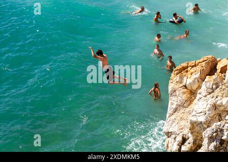 Bambini che saltano da una scogliera nel Mar Mediterraneo Foto Stock