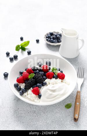 Cottage di formaggio con yogurt e frutti di bosco freschi. Cagliare con mirtilli, lamponi e mora Foto Stock