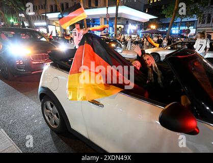 Colonia, Germania. 23 giugno 2024. Calcio: Campionato europeo, visione pubblica Svizzera - Germania. I tifosi sventolano bandiere durante una gara dopo l'ultima partita a gironi della squadra tedesca. Crediti: Roberto Pfeil/dpa/Alamy Live News Foto Stock