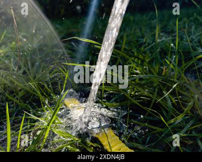 Parigi, Francia - 23 settembre 2022: Un Apple Watch Ultra 2 sdraiato sull'erba con acqua che vi versa sopra, che ne mostra la durata e la resistenza all'acqua, su Foto Stock