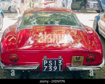 Castellarquato, Italia - 22 giugno 2024 Rally bandiera Argento , auto sportiva italiana classica rossa luccicante parcheggiata al sole con persone che camminano intorno ad una CA Foto Stock