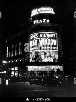 The PLAZA THEATER, Piccadilly Circus, Londra di notte nell'ottobre 1954 mostrando JAMES STEWART e GRACE KELLY nella FINESTRA POSTERIORE 1954 regista ALFRED HITCHCOCK racconto breve Cornell Woolrich sceneggiatura John Michael Hayes musica Franz Waxman Alfred J. Hitchcock Productions / Paramount Pictures Foto Stock