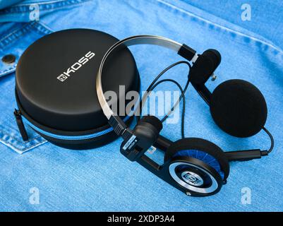 Cuffie wireless Koss porta Pro con custodia rotonda per il trasporto di una camicia in denim Foto Stock