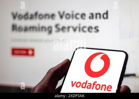 Immagine di una mano di un uomo che mostra il logo della multinazionale britannica di telecomunicazioni "Vodafone" su uno schermo di un telefono cellulare. roami Foto Stock