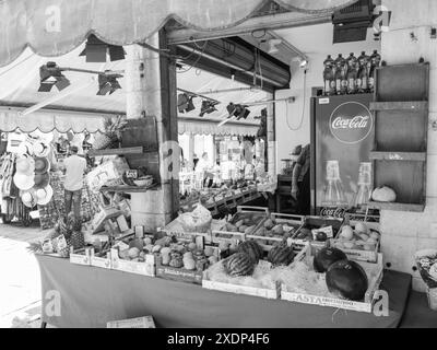 Venezia, Italia - 30 giugno 20220 immagine in bianco e nero di un venditore di frutta che organizza i suoi prodotti in una bancarella del mercato Foto Stock