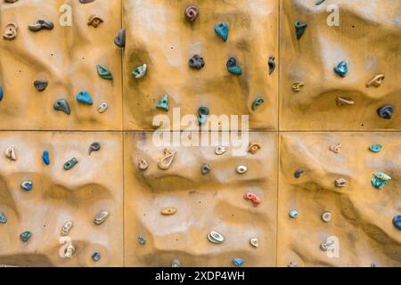 Parete per arrampicata artificiale con supporti colorati per l'allenamento di bouldering e arrampicata su roccia Foto Stock