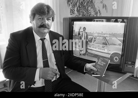 Heinz Weifenbach (Praesident des Eishockeyvereins ECD Iserlohn) presentiert *Das Grüne Buch* des lybischen Revolutionsfuehrers Muammar al-Ghaddafi, mit dem der Eishockeyverein ECD Iserlohn während eines Eishockeyspiels als Werbung auf den Trikots auflief. März 1988 a Iserlohn, Germania Foto Stock