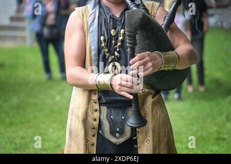 Musicista in costume medievale che suona le cornamuse in pelle e legno, esibizione di musica folk in un evento di festival del Medioevo, spazio copia, selezione Foto Stock