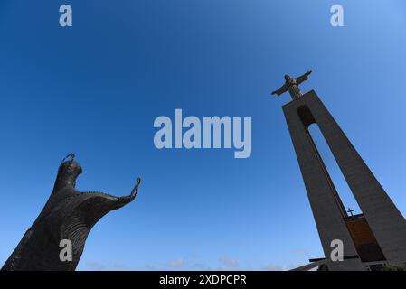 Vista ad angolo basso del Cristo Rei e delle statue della Vergine Maria al Santuario di Almada - Portogallo Foto Stock