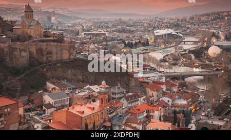 Tbilisi, Georgia 4k Timelapse. Vista dall'alto dei famosi luoghi di interesse nelle illuminazioni notturne. Città durante il tramonto e l'illuminazione notturna. Paesaggio urbano Foto Stock