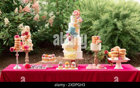 Elegante tavolo da dessert per matrimoni con torta a più livelli e vari dolci Foto Stock