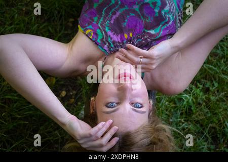 Donna stesa per terra con le mani sul viso Foto Stock
