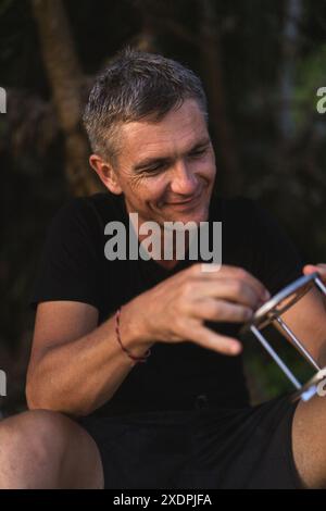 Un uomo di mezza età sulla spiaggia di Bali, sorridente. Foto Stock