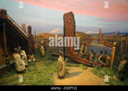 Un diorama della vita maori al museo di Milwaukee che mostra un villaggio maori con uomini e la loro canoa da guerra. Immagine sgranata ottenuta con la luce disponibile. Foto Stock