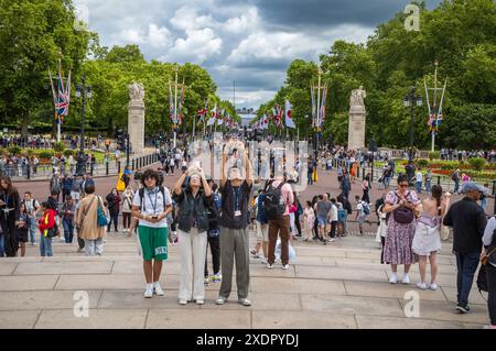 I turisti scattano foto al Victoria Memorial alla fine del Mall fuori Buckingham Palace, la residenza reale di Londra, Regno Unito Foto Stock