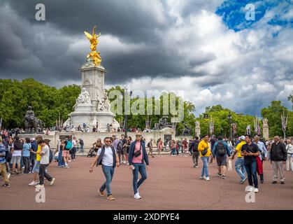 Turisti vicino al Victoria Memorial alla fine del Mall fuori Buckingham Palace, la residenza reale a Londra, Regno Unito Foto Stock