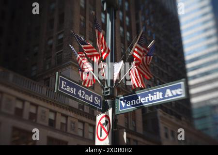 East 42nd st e Vanderbilt Avenue che attraversano New York City con American Flags Foto Stock