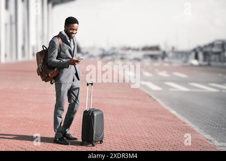 Arrivo in aeroporto. Imprenditore il controllo della posta elettronica sul telefono cellulare Foto Stock